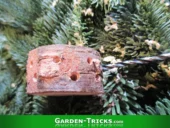 Für den wiederverwendbaren Gesteckbausatz werden einige Zentimeter des Weihnachtsbaums abgesägt. Danach werden die passenden Lochgrößen für das Tannengrün ermittelt.